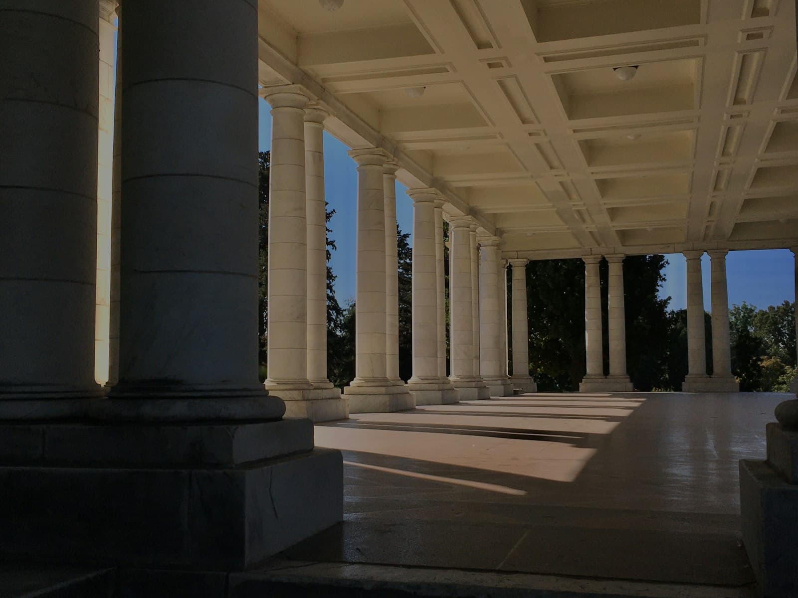 Golden-hour light through the marble colonnade of the Cheesman Park pavilion in Denver