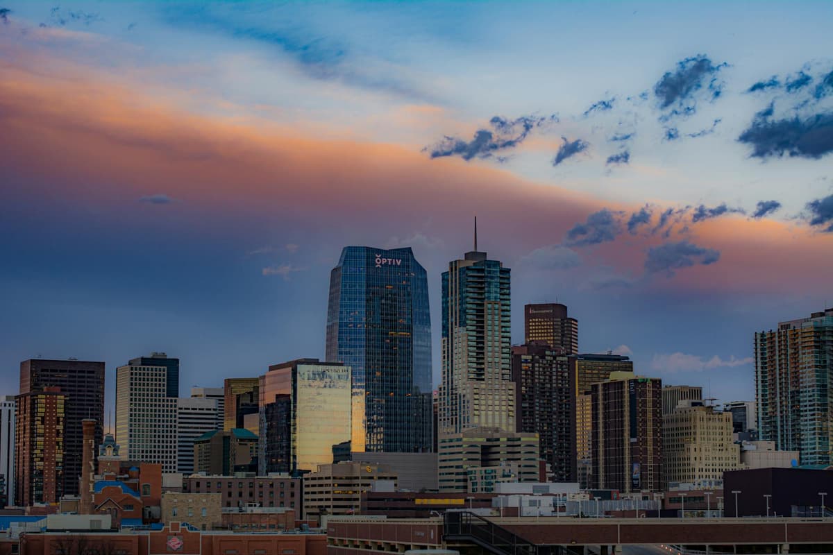 Downtown Denver's skyline at dusk under a pink and purple sky