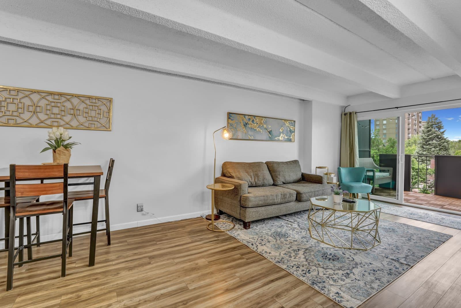 Wide view of the dining table and living area looking toward the balcony